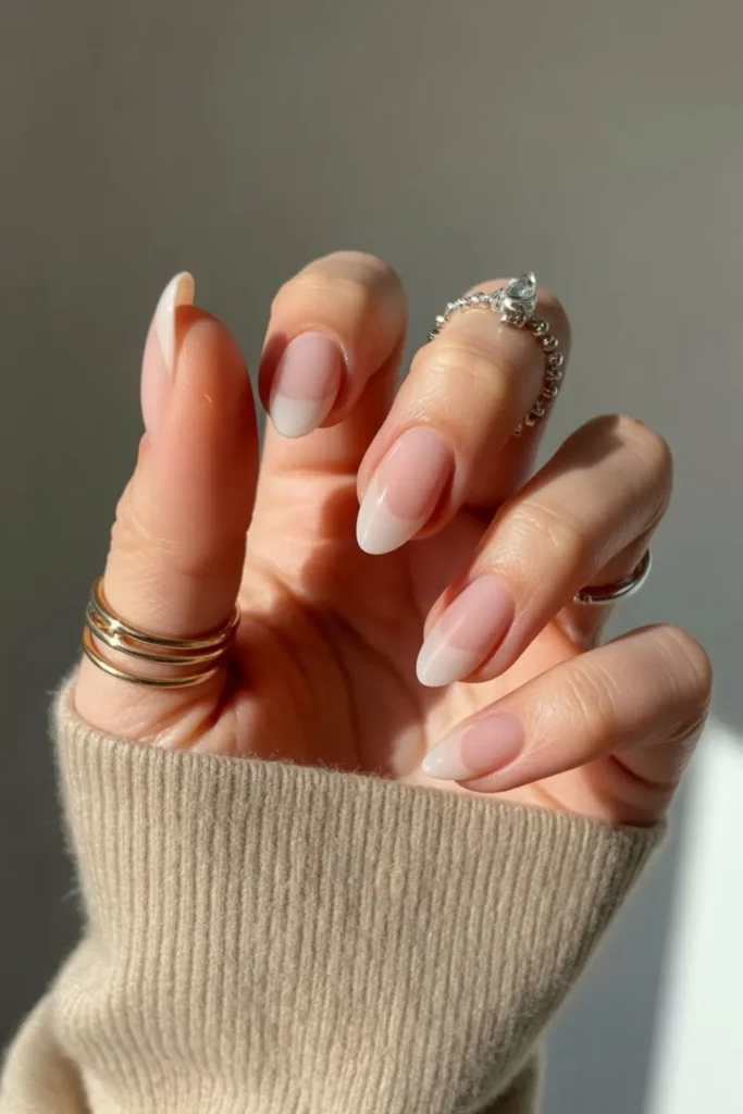 Glossy short almond nails styled with rings showing why nails 2025 trends short almond are popular.